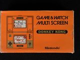 une boîte orange sur laquelle est posé un Game & Watch Multi-Screen