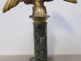 une statue d'aigle posée sur un socle