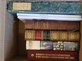 plusieurs livres empilés dans une boîte