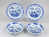 a set of four blue and white plates