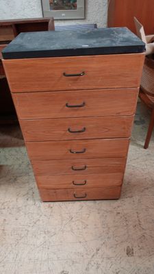 une commode en bois à cinq tiroirs avec un plateau noir