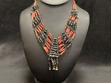 a black and orange beaded necklace on a mannequin