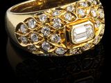 gros plan d'une bague en or avec des diamants sur une surface noire