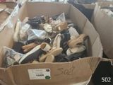 plusieurs paires de chaussures dans une boîte en carton posée sur le sol