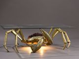 a glass table with a gold spider on it