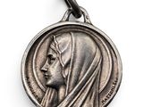 a silver medal with a woman ' s face on it