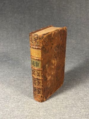 an old book sitting on top of a table next to a gray background