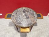 a small table with a marble top on a tile floor