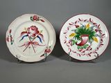 deux assiettes ornées de fleurs et d'oiseaux, posées sur un support