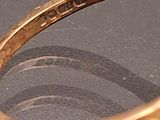 a gold ring with a diamond in it on a table