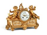une horloge dorée ornée d'anges sur fond blanc