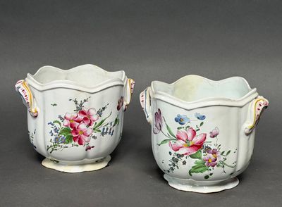 two vases with flowers painted on them on a gray surface