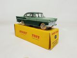 green toy car sitting on top of a yellow box on a white surface
