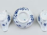 three pieces of blue and white porcelain teapots on a white surface