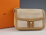 une boîte orange et blanche avec un sac à main beige et une boîte marron