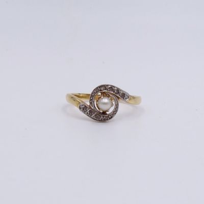 a close up of a gold ring with a pearl and diamonds