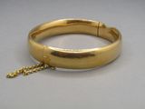 une image montrant un gros plan d'un bracelet en or muni d'une chaîne