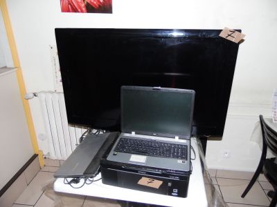 a laptop computer sitting on top of a table in front of a television