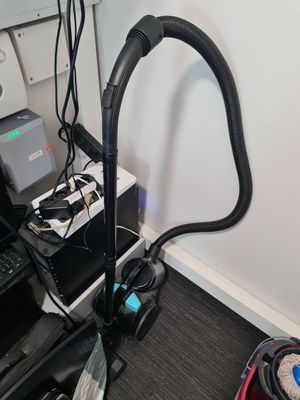 a vacuum that is sitting on a desk next to a laptop