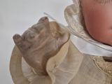 a close up of a doll with a bonnet on
