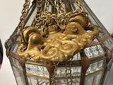 a glass and brass lamp with a chain hanging from the top of it