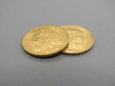 two gold coins sitting on top of each other on a table