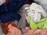 a pile of clothes in a basket on a bed