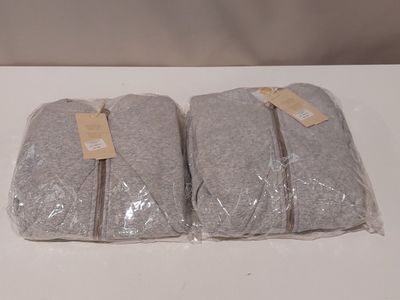 trois sacs de serviettes grises posés sur une table blanche