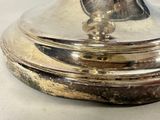 a silver plate with a bell on top of it