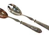 two spoons and a spoon rest on a white surface