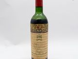 une vieille bouteille de vin posée sur une surface blanche