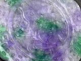a picture of a green and purple stone with a dragon on it