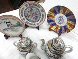 four different plates and a teapot on a table