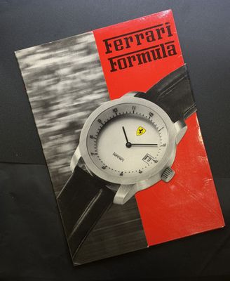 un gros plan d'un livre posé sur une table, sur lequel se trouve une montre