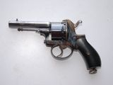 an old revolver on a white surface with a black handle