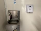 a stainless steel sink and a hand dryer in a small room