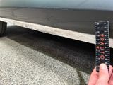 a hand holding a ruler that is next to a car