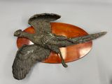 a sculpture of a bird that is sitting on a plate