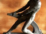 statue of a man holding a hammer on a base against a wall