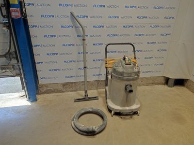 une machine posée par terre à côté d'un tuyau
