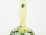 a green and yellow vase with white flowers on it