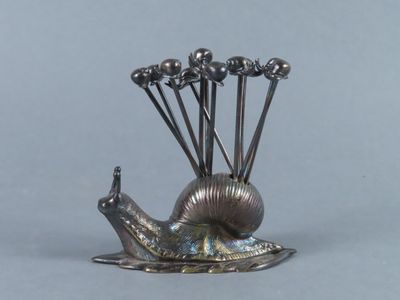 une sculpture en argent représentant un escargot, posée sur une table
