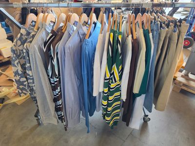 beaucoup de vêtements suspendus à une étagère dans un magasin
