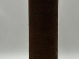 a tall brown vase sitting on a white surface