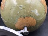 a green globe sitting on top of a table next to a wheel