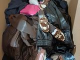 a cardboard box filled with clothes and a pair of shoes