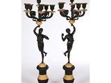 une paire de chandeliers noirs et dorés ornés de figures