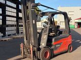 a red forklift truck parked in front of a building