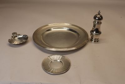 une assiette en argent et un bougeoir en argent posés sur une table
