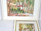 two framed paintings of a garden scene on the wall